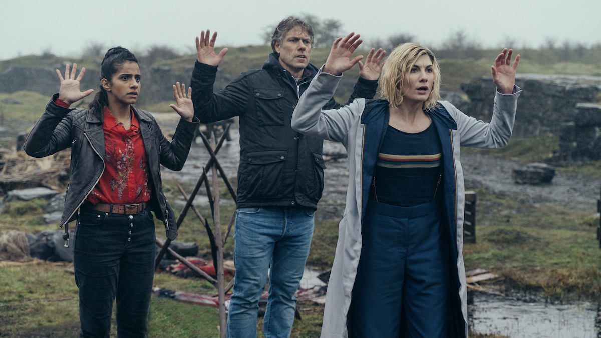 Jodie Whittaker y sus acompañantes con los brazos en alto en Doctor Who
